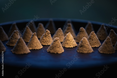 The conical moxa used for treatment is placed in a wooden dish. Moxa close-up. Moxa creative photography.