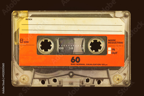 Retro styled image of an old audio compact cassette in front of a dark brown background