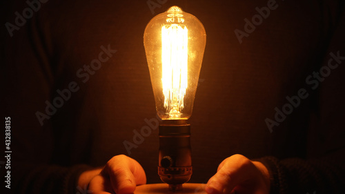 Man is holding an Edison light bulb.