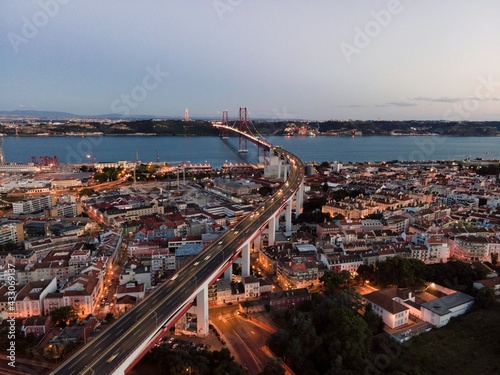 Aerial view of April 25th bridge with Christ the King statue (Cristo Rei) in background at sunset, view of Lisbon skyline at night, Alcântara, Lisbon, Portugal.