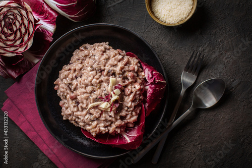 Italian risotto with radicchio rosso di Treviso, pancetta and taleggio cheese. Dark mood foto. Top view.