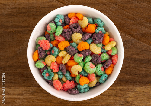 Top view of bowl with fruit cereal naturally and artificially fruit flavored sweetened corn puffs. Cereal fruity shapes