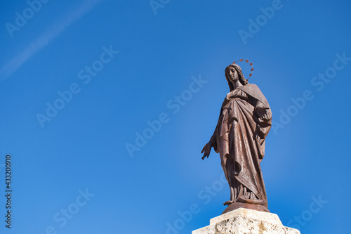 Estatua virgen María inmaculada concepción sobre cielo azul junto a la catedral de Palencia, España