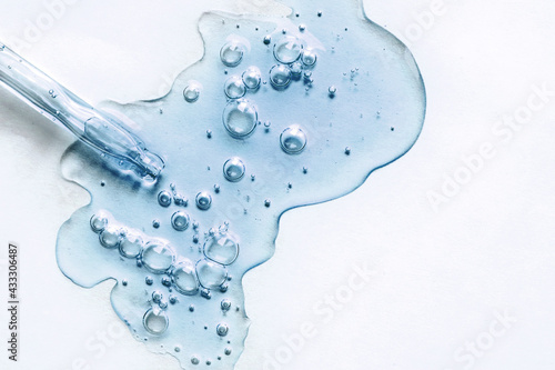 Blue texture of a drop of serum on a white background. Transparent sample of cosmetic gel with bubbles. Crystal acid cream. Hyaluronic acid.