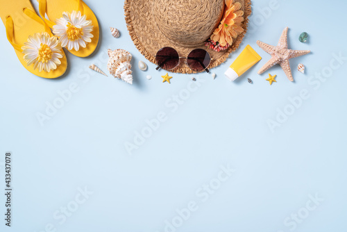 Summer beach background design concept with shells, hat, slipper on yellow background.