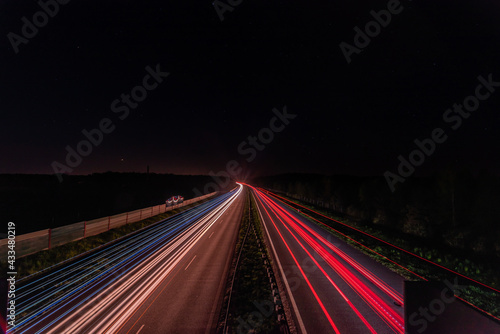 smugi świateł samochodów na autostradzie w ciemną noc