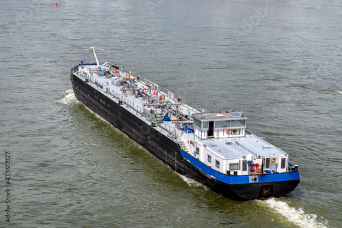 A large barge for the transport of liquid fuels sailing in Germany on the Rhine River. Transportation of oil, gas and gasoline, top view.