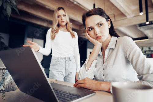 Young female boss scolding her female subordinate for bad work results