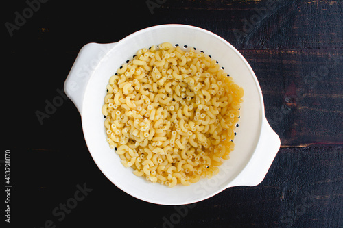 Cooked Macaroni Pasta in a Colander: Drained macaroni pasta in a plastic colander