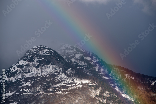 uno splendido arcobaleno sulle dolomiti, il cielo tinto di un blu scuro ed in primo piano gli splendidi colori di un'arcobaleno dopo la pioggia