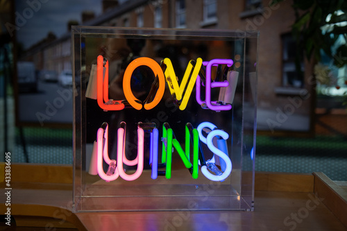 A bright colourful neon sign that says Loves Wins