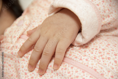 A baby girl hand with delicate skin care with sanitizer for neonatal health