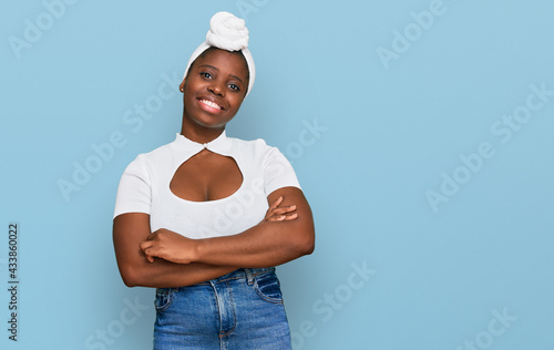Young african woman with turban wearing hair turban over isolated background happy face smiling with crossed arms looking at the camera. positive person.