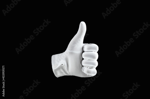 Human hand, hand in white glove isolated on black background, showing like gesture. Concept of human gesture of approval, like, cool.