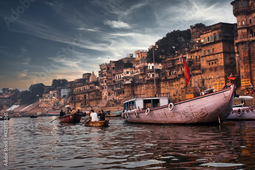 Varanasi, India: Dramatic sunset in a holy hindu place of worship with lots of tourists on boats and ancient architecture ghat located in Uttar pradesh.