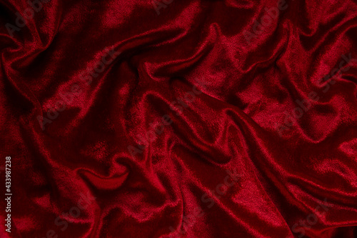 Dark red velvet textile background. Close up of fashion fabric.