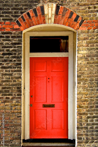 Red Door with Transom Window and arch with decorative Keystone of light colored stone