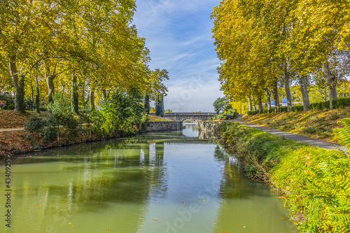 Beautiful autumn views of Canal du Midi (in XVII century - Royal Canal in Languedoc) in Toulouse and trees reflection in water. Toulouse, Haute-Garonne, France.