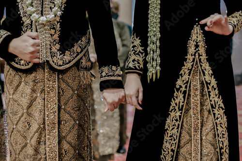 Javanese wedding as always hold each other's little finger when they are about to enter the wedding hall (kirab). Traditional Javanese wedding.