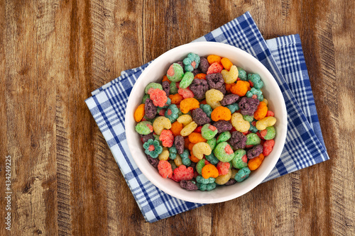Top view of bowl with fruit cereal naturally and artificially fruit flavored sweetened corn puffs. Cereal fruity shapes