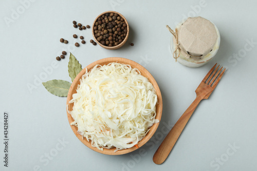 Bowl of sauerkraut and ingredients on light gray background