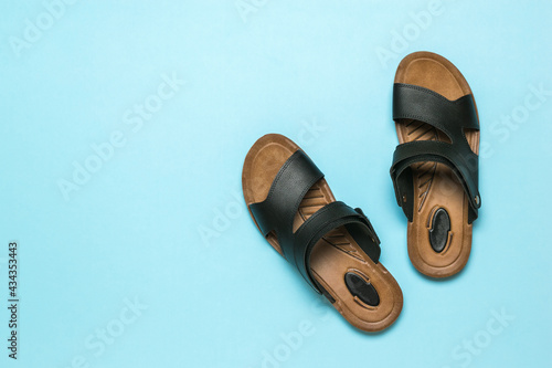 Men's leather sandals on a light blue background. Flat lay.