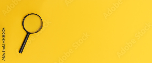 Magnifying glass on yellow colour background with copy space for text. Searching information data concept creative idea and innovation