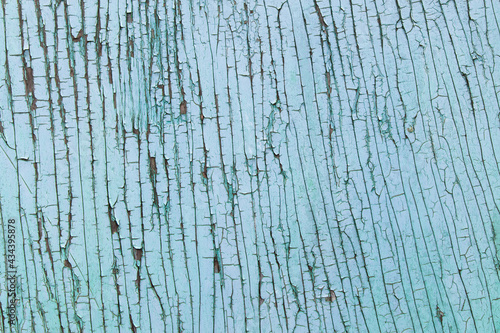 Cracked wooden surface on the wall, blue abstract backdrop with vintage effects.