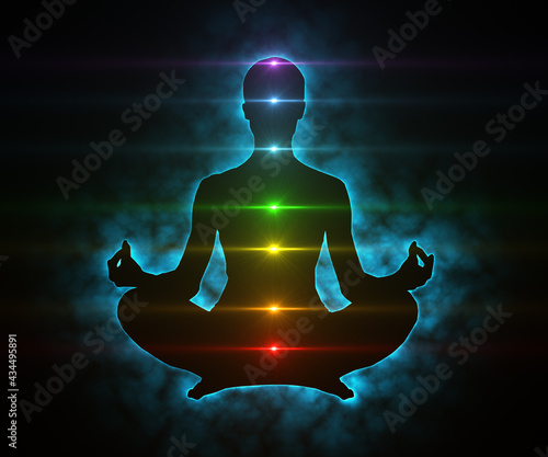 Glowing aura and chakras on meditating figure in yoga lotus pose