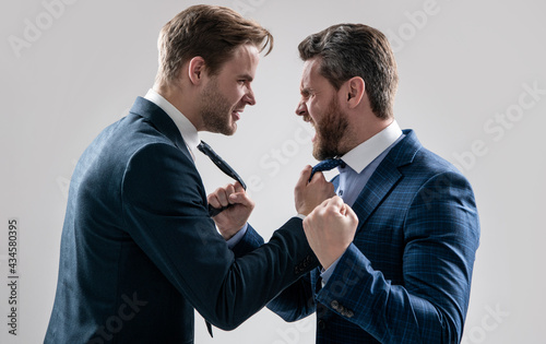 two angry businessmen punching in fight and arguing having struggle, aggressive negotiations.