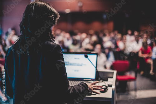 Public speaker giving talk at Business Event.