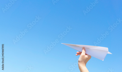 A hand of the child who flies a paper airplane. 紙飛行機を飛ばす子供の手