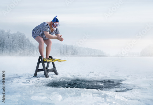 Fuunny overweight, retro swimmer about to jump into ice hole in the lake, with copy space