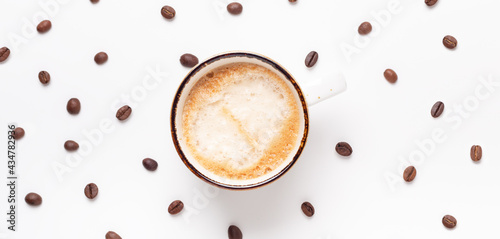 Horizontal banner with cup of coffee and coffee beans on white background. Top view. Copy space