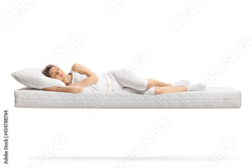 Young woman in white pajamas sleeping on a floating mattress