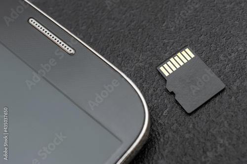 Micro SD memory card with smartphone. Close up.