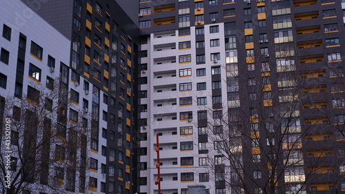 Part of a modern building. The building is from the courtyard side. High-rise building, many windows, balconies. Apartment building.