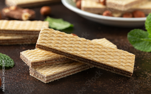 Tasty wafer biscuits with chocolate on rustic table