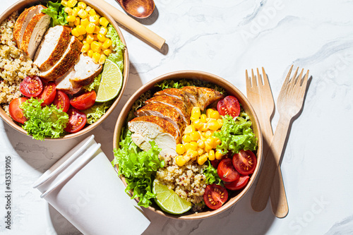 Chicken and quinoa salad with corn and tomatoes in plastic-free bowl. Zero waste, to go food, recycling packaging, eco friendly concept.