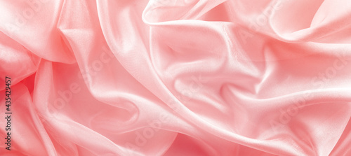 pink organza fabric draped with large folds, delicate textile background