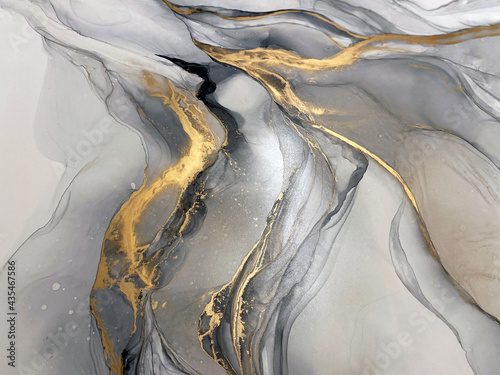 Abstract grey art with gold — black and whited background with beautiful smudges and stains made with alcohol ink and golden pigment. Gray fluid art texture resembles marble, watercolor or aquarelle.