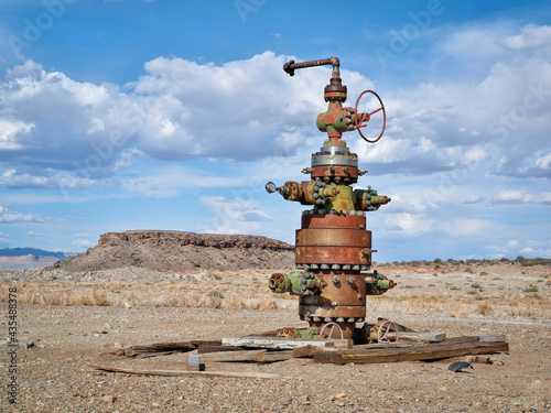 unused head of oil well with numerous valves in a desert landscape of central Utah