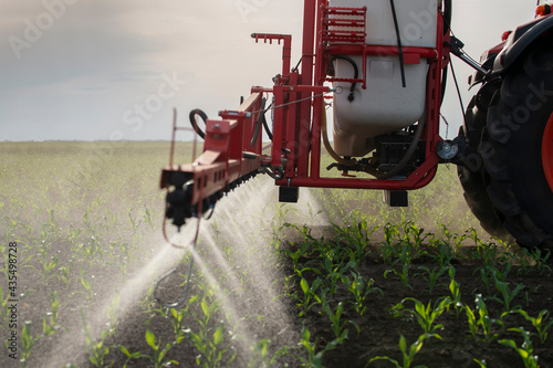 Tractor spraying pesticides at corn fields