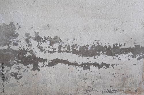 Old white concrete wall background with peeled off color surface.Caused by moisture.