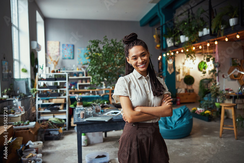 Pretty florist with cornrows looking in front of her