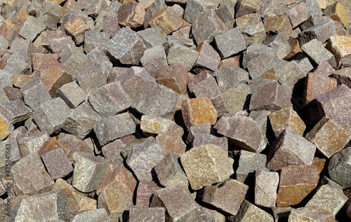 Large heap of porphyry cubes ready to be used for sidewalk or exterior pavement. Construction materials. Background and texture.