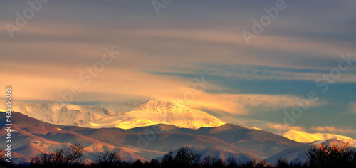 Snow covered mountain peaks in sunset. Location is Tarcu Mountains in Romania