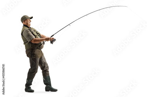 Full length profile shot of a mature fisherman in a uniform fishing
