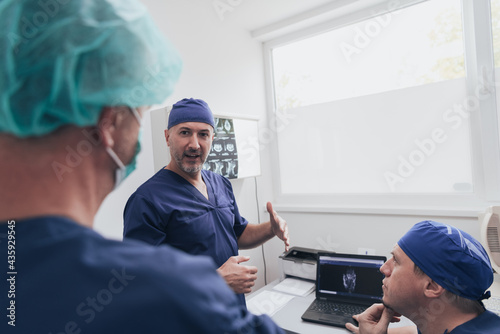 Orthopedist doctor team examining digital X-ray picture in clinic or hospital