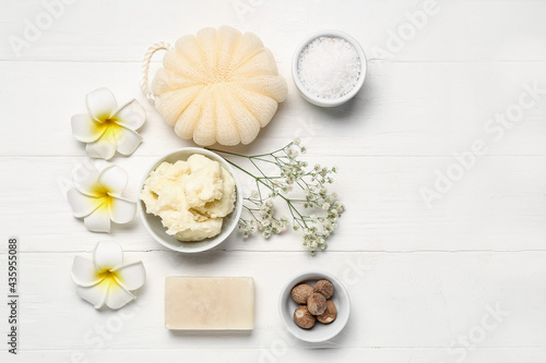 Composition with shea butter, nuts and bath supplies on light wooden background